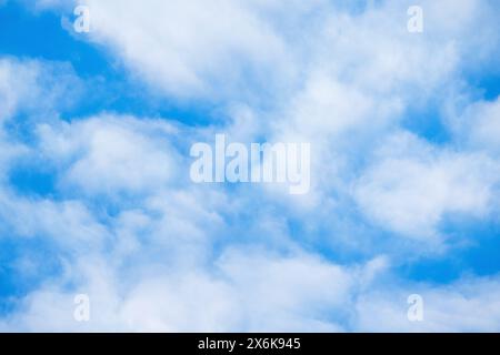 Blauer Himmel mit einer Schicht weißer Wolken an einem sonnigen Tag, natürliche Hintergrundfotostruktur Stockfoto