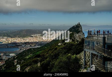Touristen auf einer Aussichtsplattform an der Bergstation der Seilbahn mit Blick auf den Felsen von Gibraltar und das spanische Hinterland, Gibraltar, Britisch Stockfoto