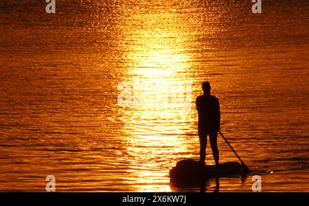 Eine Stand-up-Paddlerin genießt auf der Außenalster in Hamburg den Sonnenuntergang. *** Ein Stand-up-Paddler genießt den Sonnenuntergang auf der Hamburger Außenalster Stockfoto