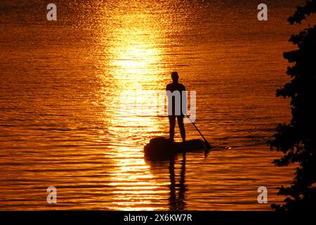 Eine Stand-up-Paddlerin genießt auf der Außenalster in Hamburg den Sonnenuntergang. *** Ein Stand-up-Paddler genießt den Sonnenuntergang auf der Hamburger Außenalster Stockfoto