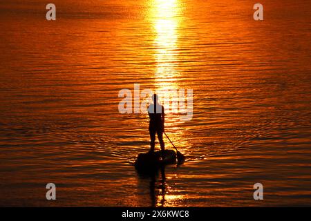 Eine Stand-up-Paddlerin genießt auf der Außenalster in Hamburg den Sonnenuntergang. *** Ein Stand-up-Paddler genießt den Sonnenuntergang auf der Hamburger Außenalster Stockfoto