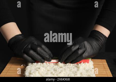 Koch in Handschuhen, Sushi-Rolle, Nahaufnahme Stockfoto