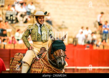 Lächelnder Picador in traditioneller Kleidung zu Pferd während einer Novillada in Sevilla. Stockfoto