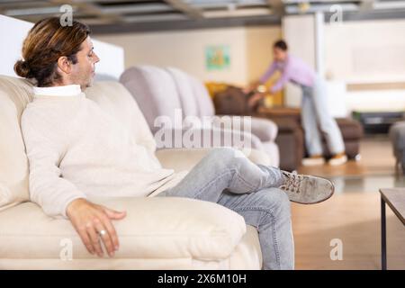 Der Mann überprüft die hohe Qualität des Sofas Stockfoto