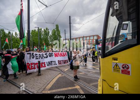 Demonstrant hält die Straßenbahn an. Palästinensische Proteste begehen den 76. Jahrestag der Nakba Manchester mit einem großen Schlüssel und Spruchbändern. Die pro-palästinensischen Demonstranten marschierten vom viktorianischen Denkmal im Stadtzentrum von Piccadilly Manchester zur Manchester University, wo ein Zeltlager im Brunswick Park eingerichtet wurde, das nun von den Demonstranten in Dr. Adnan Al-Bursh Park umbenannt wurde. Manchester UK. Bild Garyrobertsphotography/worldwidefeatures.com Stockfoto