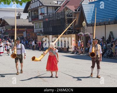 Während des Maifestes in Leavenworth, Washington, tragen Menschen in traditioneller deutscher Kleidung große Alphörner. Stockfoto