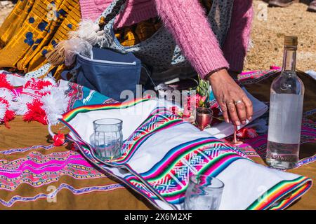 Traditionelles Ritual der Zahlung an die Erde mit Kokablättern und Chicha de jora in den Anden der Bergkette an einem sonnigen Tag Stockfoto