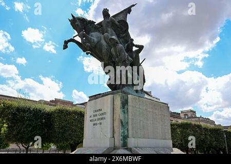 7. August 2023 - Gravina in Apulien, Italien - die Stadtvilla der Stadt mit dem Kriegsdenkmal. Die Blumenbeete und der Rasen der gepflegten Garde Stockfoto