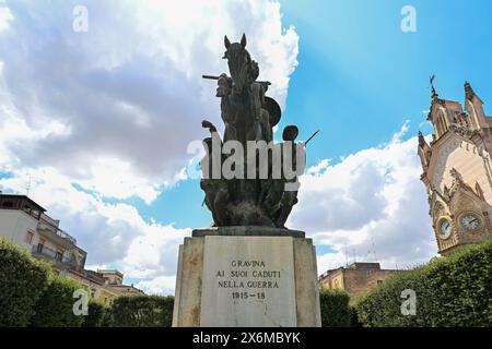 7. August 2023 - Gravina in Apulien, Italien - die Stadtvilla der Stadt mit dem Kriegsdenkmal. Die Blumenbeete und der Rasen der gepflegten Garde Stockfoto