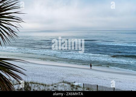 Fischer oder Mann am leeren Strand bei Sonnenaufgang Fliegenfischen im Golf von Mexiko in Destin Florida, USA. Stockfoto