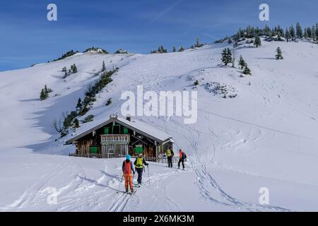 Vier Personen auf Skitour stehen an der Almhütte, am Tanzeck, Spitzinggebiet, Bayerische Alpen, Oberbayern, Bayern, Deutschland Stockfoto