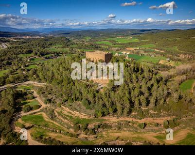 Blick aus der Vogelperspektive auf die Burg Balsareny, umgeben von grünen Feldern an einem Frühlingnachmittag (Bages, Barcelona, Katalonien, Spanien) Stockfoto