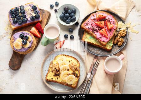 Sortiment an Süßem Toast. Banane, Frischkäse, Erdnussbutter und Erdbeere, Frischkäse und Heidelbeere auf weißem Hintergrund. Draufsicht. Stockfoto