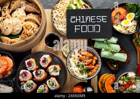 Auswahl chinesischer Speisen. Chinesische Nudeln, gebratener Reis, Knödel, Dim Sum, Frühlingsrollen. Berühmte chinesische Gerichte auf schwarzem Hintergrund. Top-Film Stockfoto