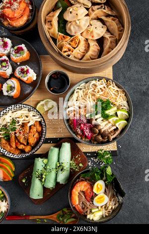Auswahl chinesischer Speisen. Chinesische Nudeln, gebratener Reis, Knödel, Dim Sum, Frühlingsrollen. Berühmte chinesische Gerichte auf schwarzem Hintergrund. Top-Film Stockfoto