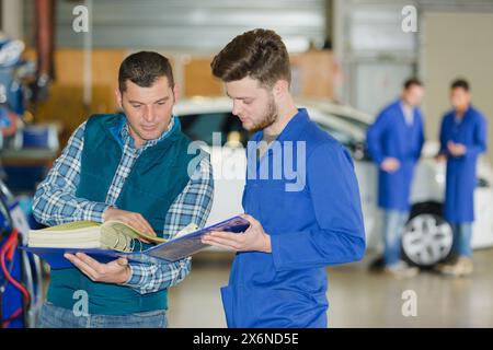 Zwei Mechaniker nehmen um in Reifen Service Stockfoto