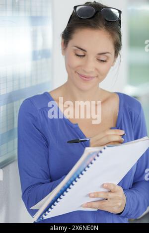 Weibliche Führungskraft schreibt auf Haftnotiz Stockfoto