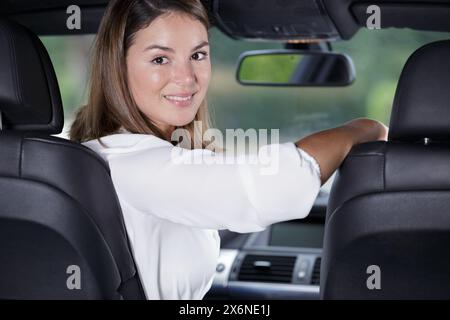 Lächelnde Mädchen sitzen in einem Auto und ein Blick zurück Stockfoto