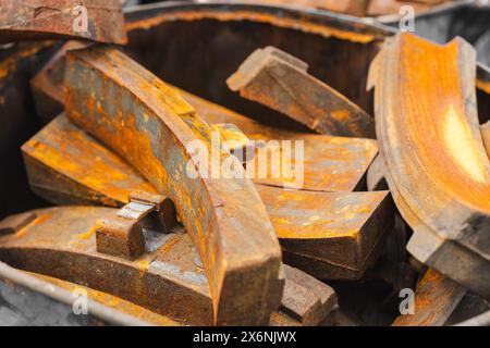 Stapel rostiger Metallteile verwendet alter Teil des Bremsbelags des Zuges, Müll, rostige Stahlstruktur. Stockfoto