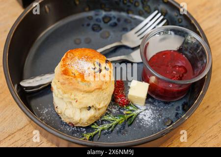 Scones mit Erdbeermarmelade, englischer Stil, traditionelles schnelles Brotmenü auf Holztisch Stockfoto