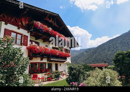 Wunderschöne traditionelle österreichische Fassaden mit Blumen dekoriert Stockfoto