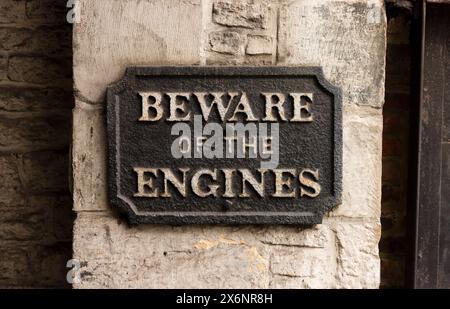 Vorsicht vor dem viktorianischen gusseisernen Schild in einem Dampfmaschinenraum. Steampunk im Retro-Stil kann verwendet werden, um Angst vor Maschinen und künstlichem i zu zeigen Stockfoto