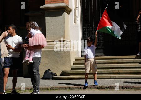 Ein palästinensischer Junge hält eine palästinensische Flagge während der ersten Demonstration in Polen, die von Studenten und Gelehrten gegen den israelischen Angriff auf den Gazastreifen am 15. Mai 2024 vor dem Collegium Novum, dem Büro des Dschagiellonischen Universitätsdekans in Krakau, Polen, organisiert wurde. Stockfoto