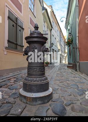 Poller zur Einschränkung der Bewegung von Autos, dekorative Säule auf dem Bürgersteig der Stadtstraße. Die Pfosten befinden sich auf einem Fußweg in der Altstadt von Riga, Lettland. Stockfoto