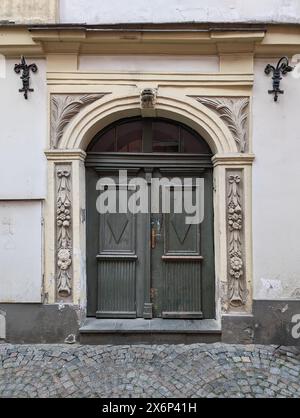 Alte Holzeingangstür in einer alten Retro-Gebäudefassade. Stockfoto