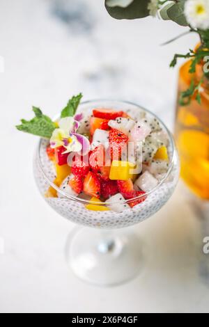 Chia Samenpudding mit Erdbeeren, Mango, Drachenfrucht im Glas auf Marmortisch. Gesundes vegetarisches Frühstück oder Snack. Stockfoto