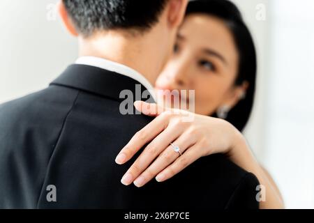 Nahaufnahme des Bräutigams, der den Diamantring am Finger der Braut platziert, symbolisiert die ewige Liebe und Verpflichtung – Konzept der Hochzeitszeremonie Stockfoto