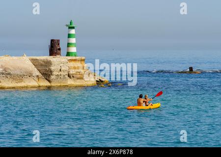 Jaffa, Israel - 10. Mai 2024: Sehen Sie den Eingang zum historischen Hafen von Jaffa mit Leuchtturm und Seeleuten. Jetzt Teil von Tel-Aviv-Yafo, Israel Stockfoto