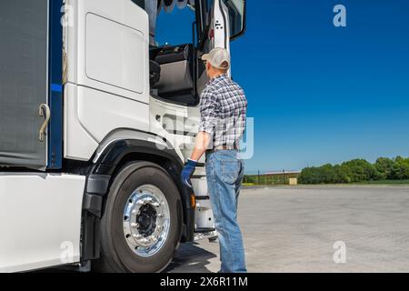 Kaukasischer Semi-Truck-Fahrer in seinen 40ern, der sich auf die Arbeit vorbereitete. Thema Transportbranche. Stockfoto