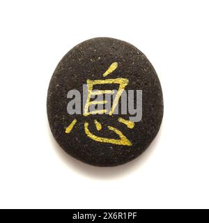 Chinesisches Zeichen xi oder japanisches Iki, was Ruhe bedeutet, geschrieben auf Kieselstein Stockfoto