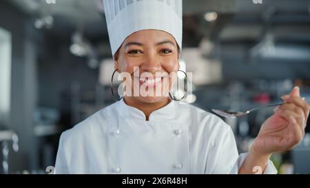 Restaurant Küche: Porträt der schwarzen Chefkoch, die Gerichte zubereitet, Essen verkostet und es genießt. Professionelles Kochen köstliches, authentisches, traditionelles Essen, mit gesunden Zutaten für Mahlzeit Rezept Stockfoto