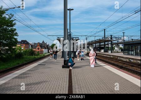 Vilvoorde, Flämisch Brabant, Belgien - 14. Mai 2024 - wartende Passagiere am Bahnsteig und Gleis des örtlichen Bahnhofs Stockfoto