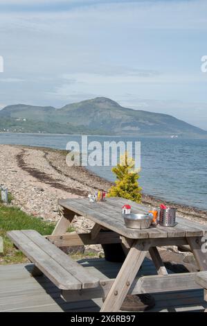 Blick auf Whiting Bay, Whiting Bay, Isle of Arran, Schottland, Großbritannien - Blick auf Holy Island, Firth of Clyde, Tisch, Bank; Café; stoney Beach Stockfoto