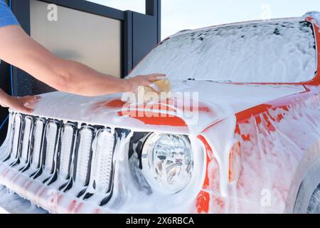 Auto in Schaum in einer Autowaschanlage. Autowäsche mit Seife, Autowäsche, Selbstbedienung Stockfoto