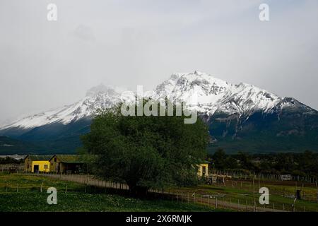 Eine Estancia im Nationalpark Los Glaciares, umgeben von grünen Hügeln, schneebedeckten Bergen und dem Argentino-See. Stockfoto