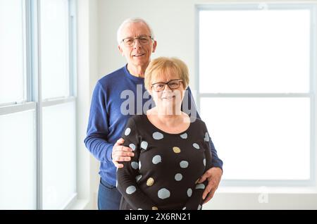 Fröhliches, träumliches, älteres Ehepaar der 60er Jahre, das sich vor Liebe umarmt Stockfoto