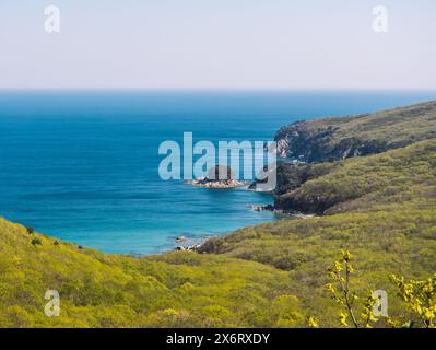 Ruhige Aussicht auf die zerklüftete Küste und das klare blaue Meer an einem sonnigen Tag Stockfoto