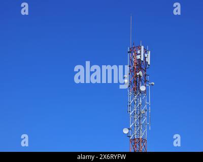Mobilfunktürme türmen sich hoch vor blauem Himmel Stockfoto