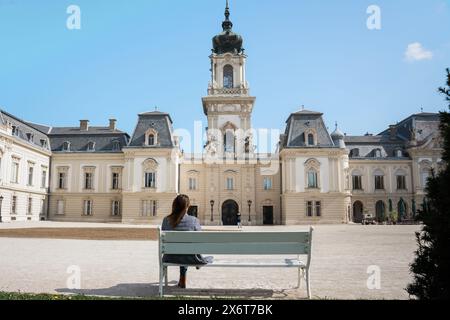 Wunderschönes barockes Festetics Schlossgebäude in Keszthely Ungarn mit einer Frau, die auf einer Bank sitzt Stockfoto