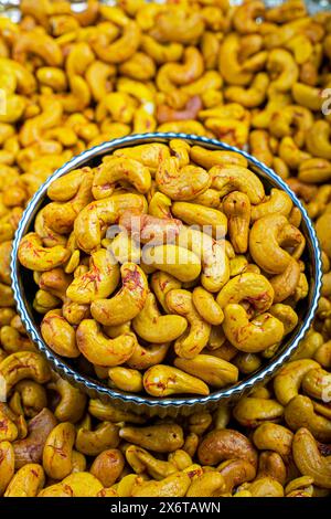 Nahaufnahme von Safran-Cashews in A Decorative Bowl, Ein hochauflösendes Bild mit Safran-Cashews in einer dekorativen blau-weißen Schale. Stockfoto