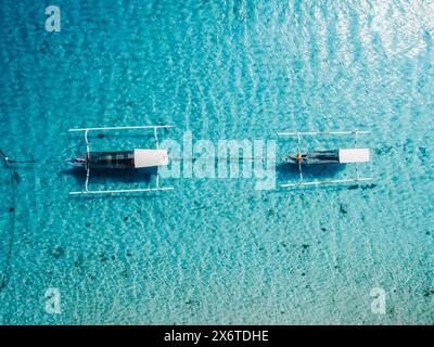 Motorboote im blauen transparenten Meer auf tropischer Insel. Draufsicht der Drohne. Stockfoto