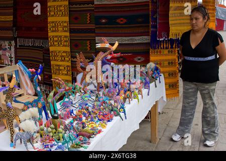 Tlacolula, Oaxaca, Mexiko. Tlacolula-Markt. Mexikanische Frau, die handbemalte Holztiere verkauft, Alebrijes. Stockfoto