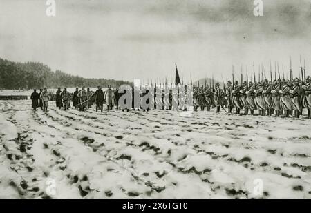 Eine Illustration zeigt General Joffre, wie er seine Soldaten während des Ersten Weltkriegs auf einem schneebedeckten Feld in Lothringen beobachtet. Diese Szene fängt einen Moment der Inspektion und der Moral an, während General Joffre, ein wichtiger französischer Militärführer, seine Truppen unter den schwierigen Winterbedingungen überwacht. Lothringen war eine bedeutende Region militärischer Operationen, was die anhaltenden Bemühungen der französischen Armee widersetzte und sich gegen deutsche Truppen zurückdrängte. Stockfoto