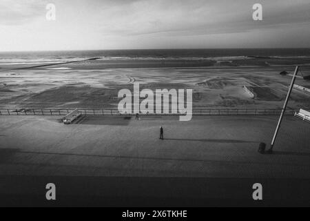 Menschen an einer leeren Strandpromenade mit Blick auf das Wattenmeer. Middelkerke, Belgien Stockfoto