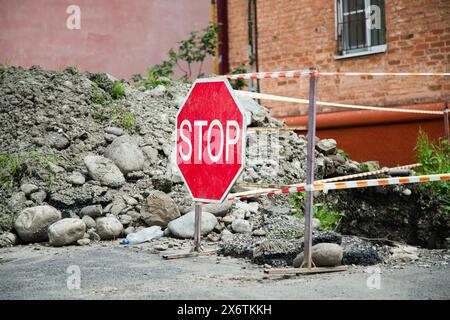 Der Reparaturort an der Stadtstraße ist mit einem weißen Signalband umzäunt Stockfoto