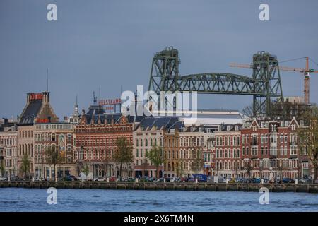 Blick auf die Stadt mit alten Gebäuden am Flussufer und einer Eisenbahnbrücke im Hintergrund, Skyline einer modernen Stadt am Fluss mit einer modernen Brücke Stockfoto